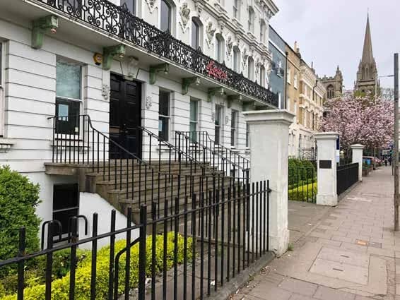 The stucco front of Cintra House on Hills Road, with its cast-iron balcony, before the works