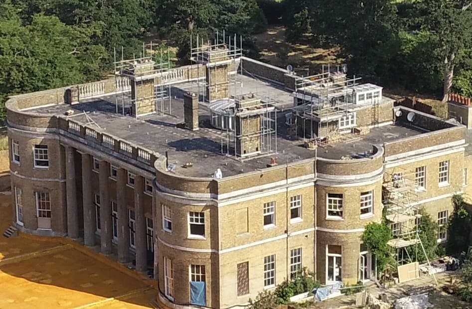 Sacombe House during works, with scaffolding around the chimneys