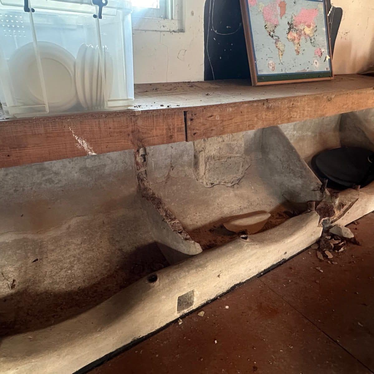 A long rendered brick trough inside the barn
