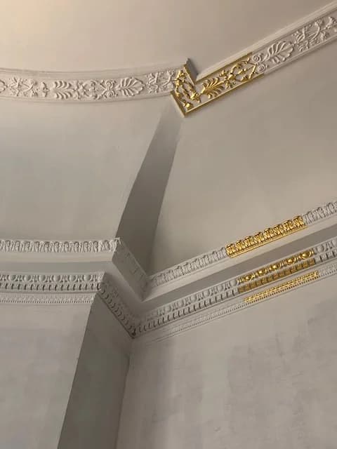 Detail of pale ceiling mouldings with gilded ornament